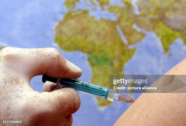 Vorschriftsmäßig mit einem Schutzhandschuh bekleidet, impft ein Arzt am 10.7.2000, dem Eröffnungstag des größten Impfzentrums Deutschlands in...
