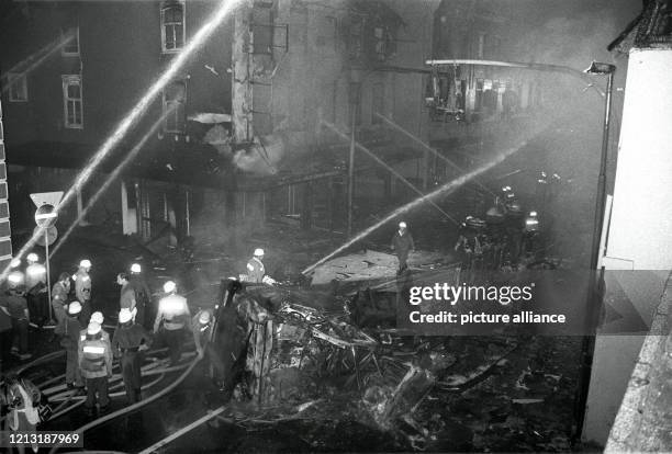 Feuerwehrleute bei Löscharbeiten an der Unglücksstelle mit dem ausgebrannten Wrack des Tanklastzuges am 8.7.1987. Nach dem Versagen der Bremsanlage...