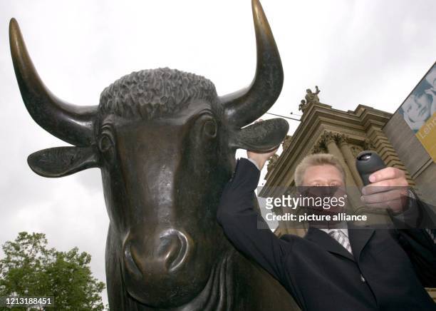 Frank Hackenbuchner, Vorstandschef der Marburger media AG, packt am 5.7.2000 den Bronzebullen vor der Börse in Frankfurt/Main am Ohr. Die Aktien des...