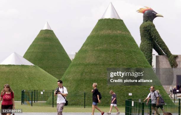 An riesigen, grasbewachsenen Kegeln gehen Besucher am 4.7.2000 auf der Expo in Hannover vorbei. Zu Beginn der Weltausstellung waren viele Besucher...