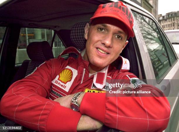 In einem originalgetreuen, knallroten Rennanzug des Formel 1-Piloten Michael Schumacher lehnt sich das "Schumi"-Double Frank Saasen am 31.3.2000 in...