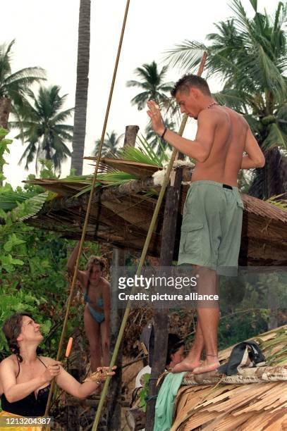 Aus Palmblättern, die auf ein Holzgestell gelegt werden, bauen Stefanie und Tjalf, Teilnehmer der SAT.1-Abenteuer-Show "Das Inselduell", am 3.6.2000...