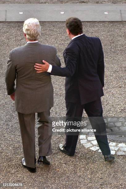 Bundeskanzler Gerhard Schröder legt am 2.6.2000 dem amerikanischen Präsidenten Bill Clinton auf dem Weg zum Familienfoto vor dem Berliner Schloss...