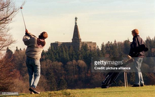 Vor der Kulisse des Kasseler Herkules spielen am 6.1.1999 zwei Golfer unter fast frühlingshaften Bedingungen die erste Partie des noch jungen Jahres....