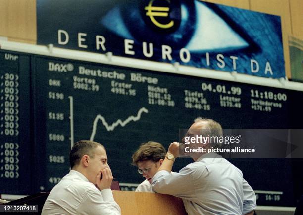 Aktienhändler am 4.1.1999 vor der Kurstafel in der Frankfurter Börse, über der in großen Buchstaben "Der Euro ist da" steht. Seit dem 4.1. Wird in...