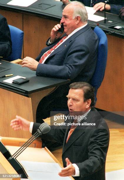 Auf seinem Platz in der Regierungsbank sitzend, telefoniert Bundeskanzler Helmut Kohl während SPD-Kanzlerkandidat Gerhard Schröder am 3.9.1998 seine...