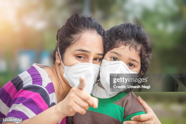 mãe e filho usam máscara facial durante o vírus da coroa e surto de gripe. proteção contra vírus e doenças - nose mask - fotografias e filmes do acervo