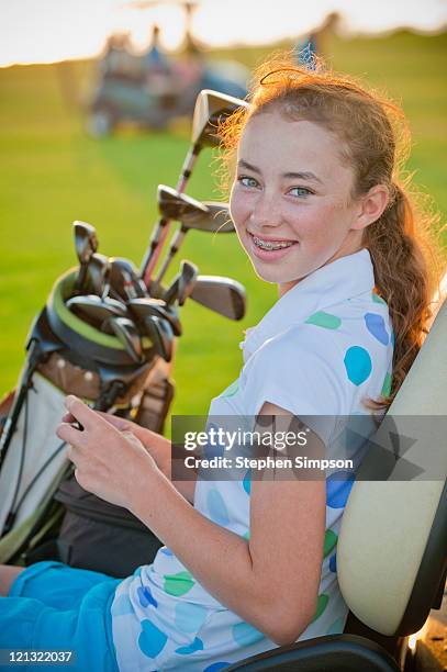 teen girl texting from a golf cart/course - golf girls stock pictures, royalty-free photos & images