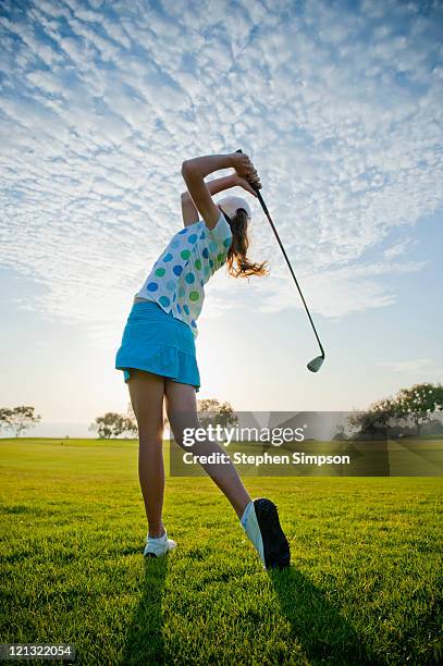 teen girl makes a powerful drive on a golf course - golf girls stock pictures, royalty-free photos & images