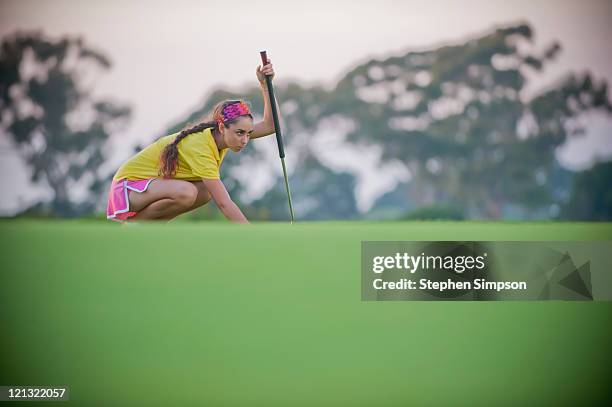 teen girl lines up a put on the golf course - golf girls stock pictures, royalty-free photos & images