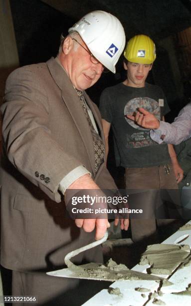 Mit tief in das Gesicht gerutschtem Schutzhelm und Mörtelkelle in der Hand beweist Bundesarbeitsminister Norbert Blüm am 21.8.1998 auf dem Potsdamer...