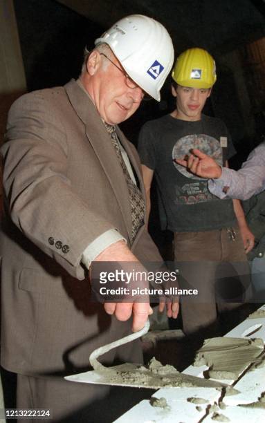 Mit tief in das Gesicht gerutschtem Schutzhelm und Mörtelkelle in der Hand beweist Bundesarbeitsminister Norbert Blüm am 21.8.1998 auf dem Potsdamer...