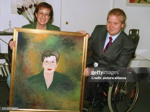 Gut gelaunt nimmt die schleswig-holsteinische Ministerpräsidentin Heide Simonis am 19.8.98 in ihrem Amtszimmer in Kiel ein Porträtgemälde in Öl des...