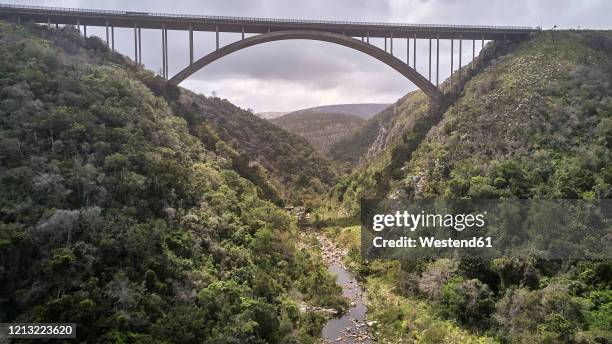 south africa, knysna area, aerial view of bridge on river in mountain landscape - garden route stock-fotos und bilder
