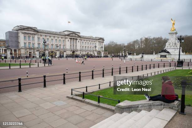 Woman watches the Changing of the Guard ceremony outside Buckingham Palace on the day that Queen Elizabeth II is set to move to Windsor Palace in a...