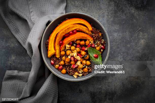 red quinoa with baked pumpkin, chickpeas, pomegranate, basil, walnuts and pumpkin seeds - quinoa and chickpeas stock pictures, royalty-free photos & images