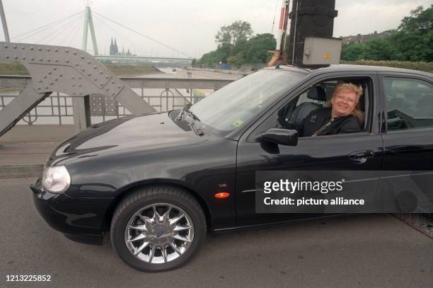 Der deutsche Aktionskünstler HA Schult am 4.8.1998 mit seinem Ford Mondeo im Kölner Hafen. Auch HA Schult ist Autofahrer. Doch in seinen...