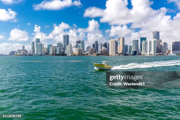 usa, florida, skyline of downtown miami with motorboat on the water - miami skyline stock-fotos und bilder