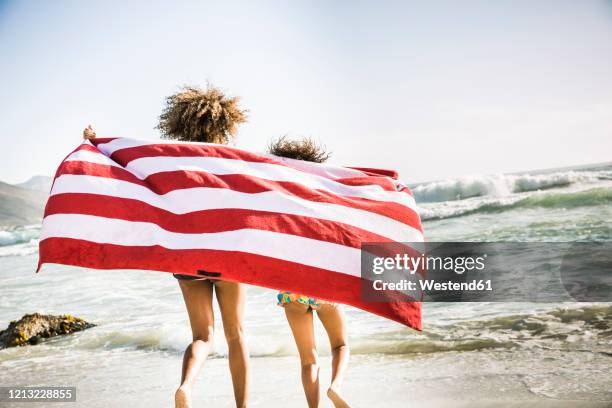 mother and daughter with towel on the beach - striped towel stock pictures, royalty-free photos & images