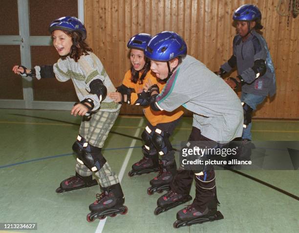 Schülerinnen und Schüler der Frankfurter Bonifatius-Grundschule fegen am während des Sportunterrichts auf Inline-Skates durch die Sporthalle. Im...