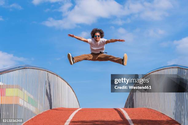 dancer jumping on bridge, mid air - man tackling stock pictures, royalty-free photos & images