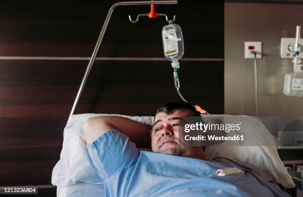 patient lying in hospital bed - hospital bed with iv stock pictures, royalty-free photos & images