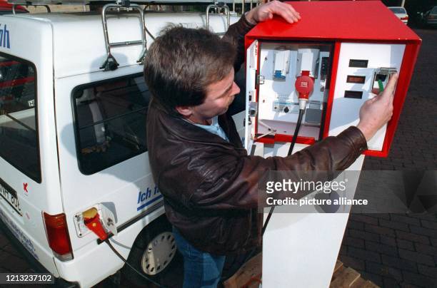 Ein Mann "tankt" sein Elektro-Auto an einer neuen "Zapfsäule" in Bremen. Mit einer neuartigen Tankstelle für Elektroautos wollen die Überlandwerke...