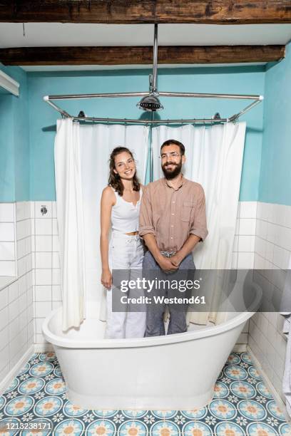 young couple standing in bath tub, laughing - woman shower bath stock-fotos und bilder