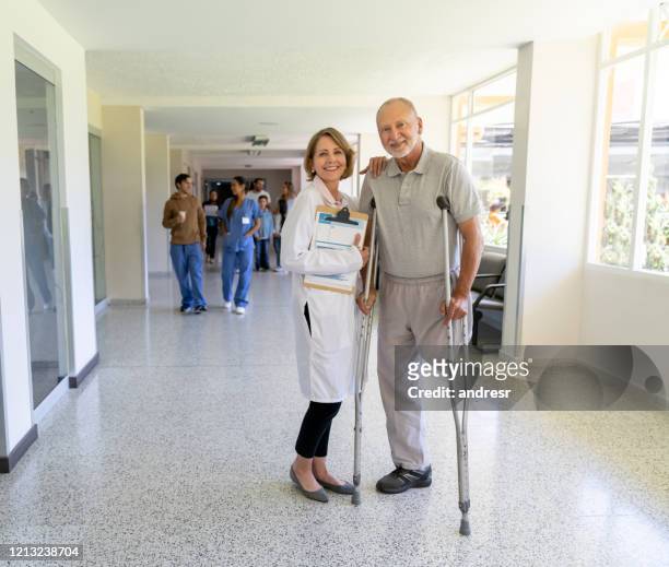 disabled patient looking happy with a doctor at the hospital - diabetic amputation stock pictures, royalty-free photos & images