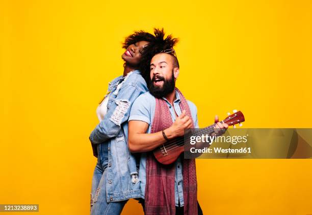 happy young man with woman in studio playing ukulele - duet stock pictures, royalty-free photos & images