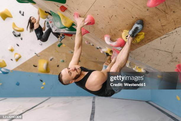 man and woman bouldering in climbing gym - bouldering - fotografias e filmes do acervo