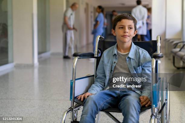 boy in a wheelchair looking bored at the hospital - sad child hospital stock pictures, royalty-free photos & images