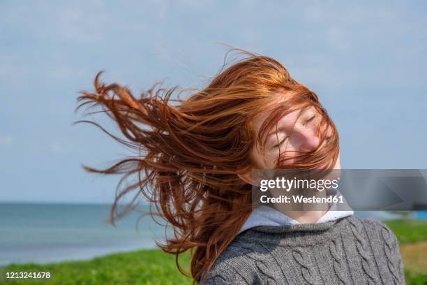 windswept hair of a teenage girl at the coast, skane, sweden - flatterndes haar stock-fotos und bilder