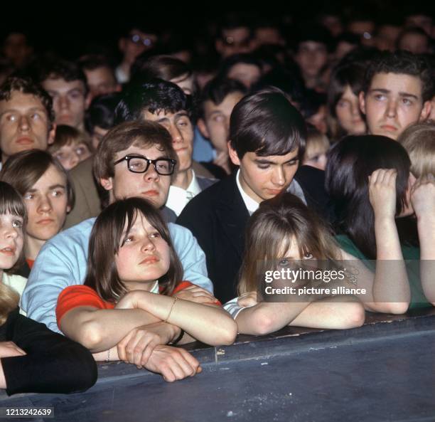 Jugendliche Zuhörer warten während eines Rock-Konzerts in den 70er Jahren teils gespannt, teils gelangweilt darauf, daß der Funke überspringt.