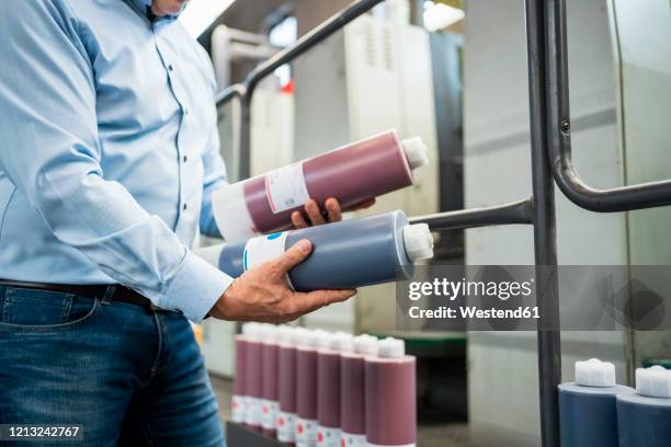 close-up of businessman holding toner in a printing plant - holding two things stock pictures, royalty-free photos & images