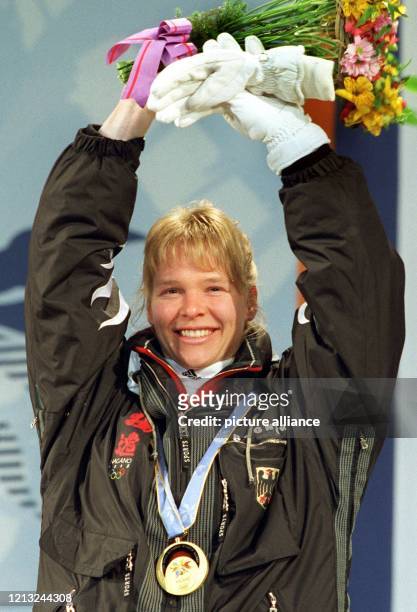 Freudestrahlend winkt Abfahrts-Olympiasiegerin Katja Seizinger nach der Medaillenzeremonie am 17.2.1998 bei den Olympischen Winterspielen in Nagano...