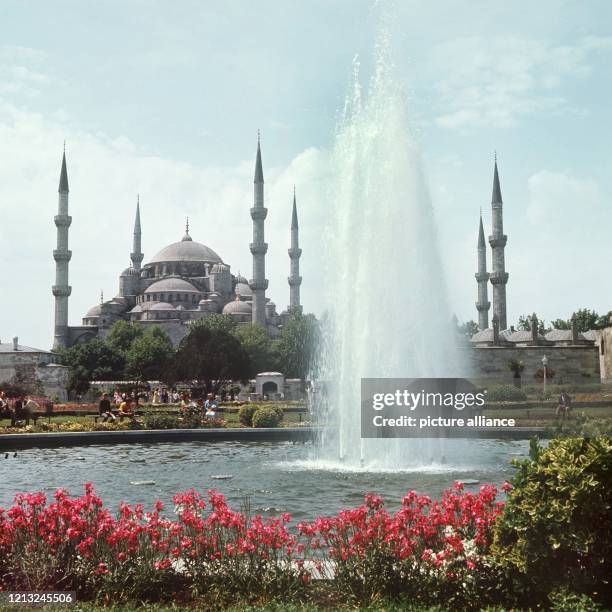 Ein Park mit Blumenbeeten und einem Springbrunnen vor der der Sultan Ahmed-Moschee, die auch Blaue Moschee genannt wird. .