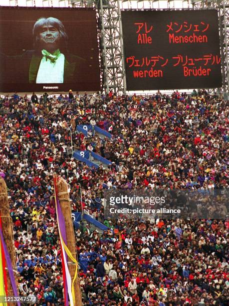 Videowände zeigen am 7.2.1998 während der Eröffnung der XVIII. Olympischen Winterspiele im Olympiastadion von Nagano den japanischen Dirigenten Seiji...