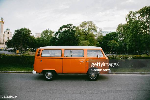 classic volkswagen camper van in white and orange - volkswagen stock pictures, royalty-free photos & images