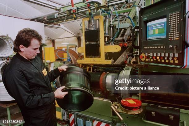 Ein Mitarbeiter des Reifenherstellers Continental AG fügt an einer Reifen-Aufbaumaschine die einzelnen Elemente eines späteren Reifens zusammen,...