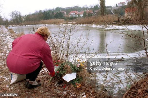 Eine Frau legt am 28.1.1998 Blumen an die Stelle, wo Carla am 22.1. Überfallen, sexuell mißbraucht und anschließend in diesen Weiher bei Wilhermsdorf...