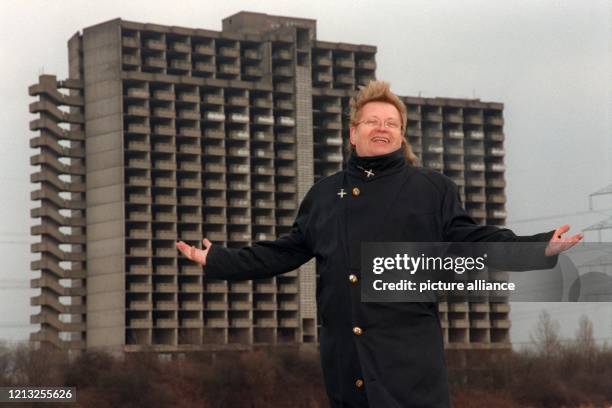 Der Künstler HA Schult steht mit weit ausgebreiteten Armen am 21.1.1998 vor der als "Kaiser-Bau" bekannten Bauruine in Troisdorf bei Bonn. Das seit...