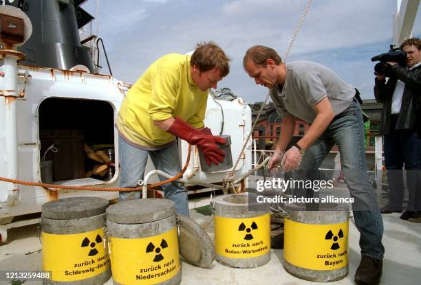 An Bord ihres Schiffes "Rainbow C" verstauen am 27.6.1997 in Hamburg zwei Mitglieder der Umweltschutzorganisation Greenpeace Atomabfall in...