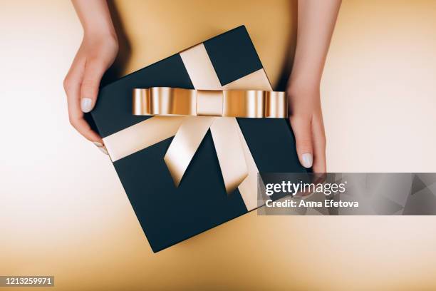 festive present box with golden bow - luxary stock pictures, royalty-free photos & images