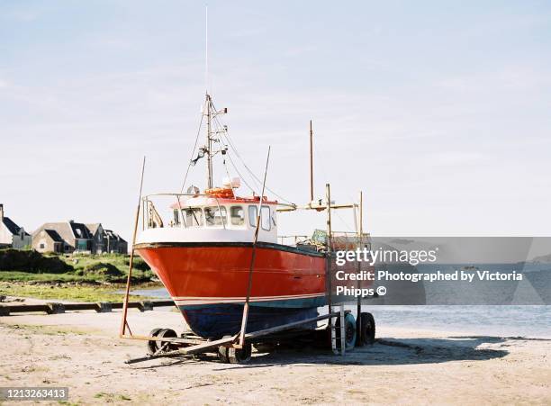 traditional fishing boat moored on a scottish beach one sunny day - アイラ ストックフォトと画像