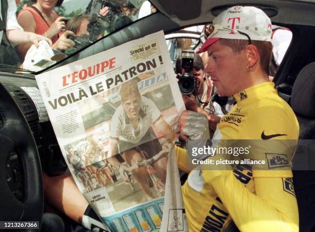 Der deutsche Radprofi Jan Ullrich vom Team Deutsche Telekom liest im Gelben Trikot des Spitzenreiters der Tour de France am 16.7.1997 vor dem Start...