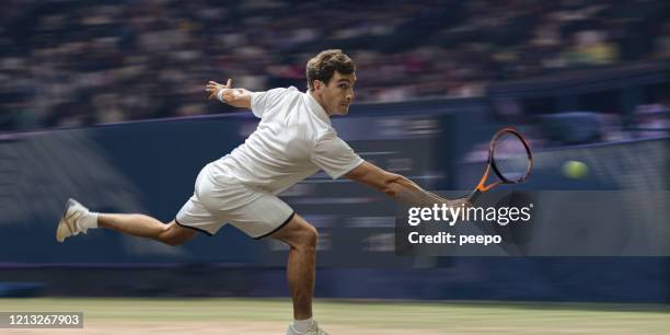 professional male tennis player in mid motion on grass court - tennis grass stock pictures, royalty-free photos & images