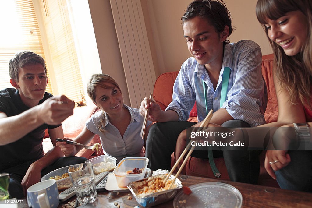 Young adults eating dinner in shared house