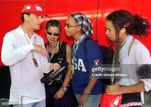 Der britische Formel 1-Pilot Eddie Irvine erklärt Jazzy, Lee und Ricki von der deutschen Mädchenband "Tic Tac Toe" am 26.7.1997 in der Ferrari-Box am...