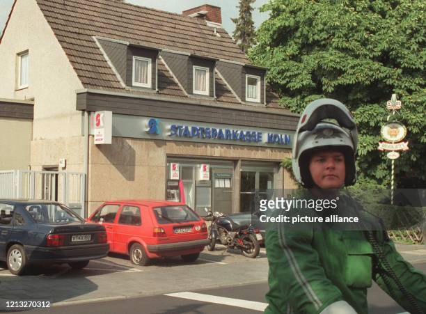 Ein Polizist steht am 25.7.1997 nach dem Ende einer Geiselnahme vor einer Filiale der Stadtsparkasse Köln. Ein 39 Jahre alter Mann war am Morgen in...